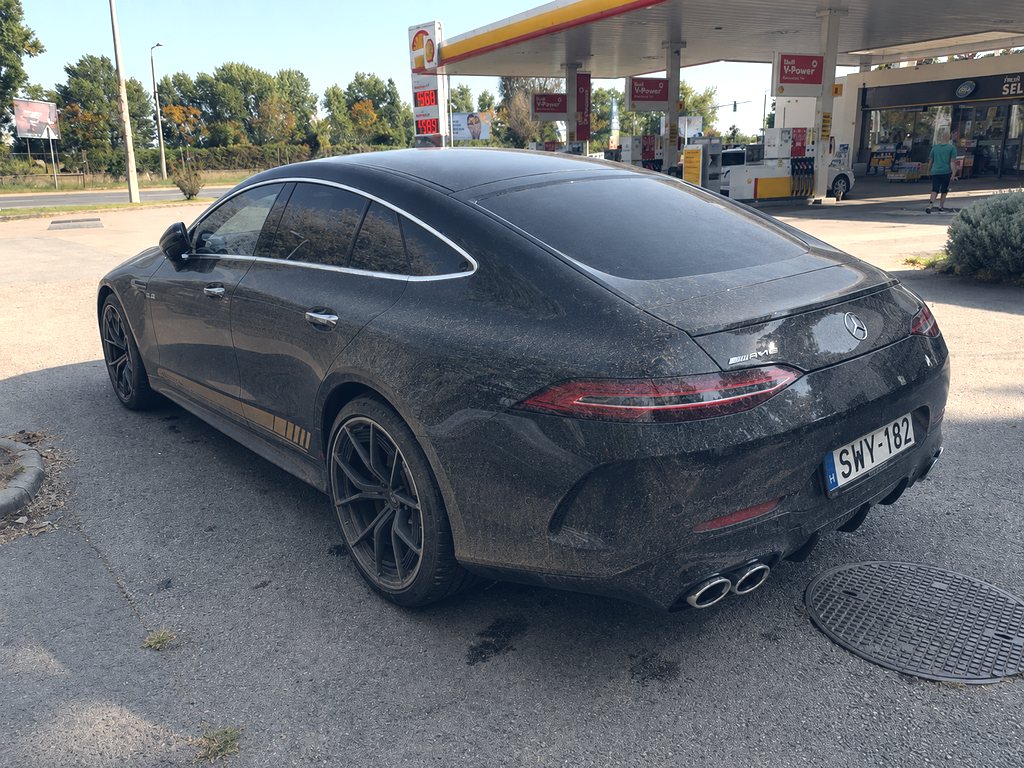 Poros, mosás előtti fekete Mercedes-AMG GT a benzinkútnál, hátsó háromnegyedes nézet