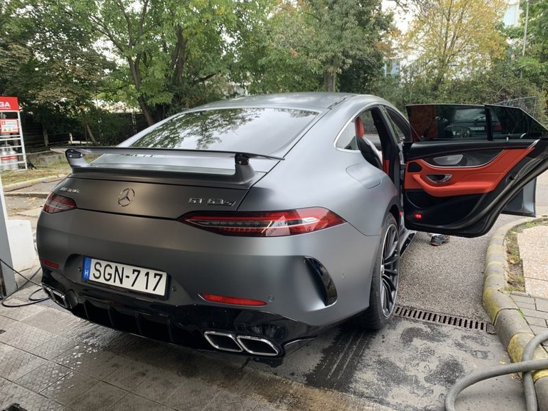 Mercedes-AMG GT 63 S kézi mosás közben, nyitott ajtóval és a talajon futó vízzel